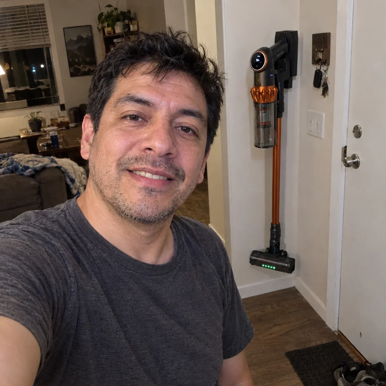 Luis in his apartment at night with the Vekto Vacuum V18 on its dock by the door